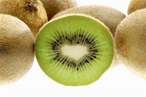 Half a kiwi fruit surrounded by whole fruit