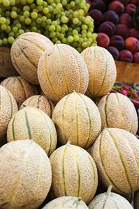 Fresh melons, grapes and peaches at a market