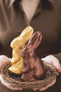 Woman holding two Easter Bunnies in Easter nest