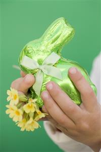 Child's hands holding green Easter Bunny