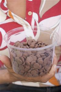 Person holding tub of chocolate buttons