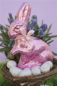 Pink Easter Bunny & Easter eggs in basket, spring flowers