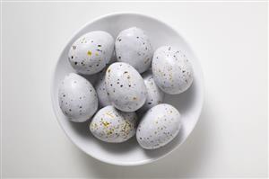 Speckled chocolate eggs in white dish