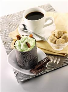 Small chocolate cake with pistachio cream, cup of coffee, sugar