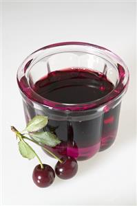 Cherry jelly in small jelly mould, fresh cherries beside it