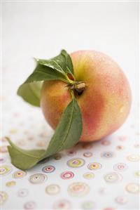 Nectarine with leaves and drops of water