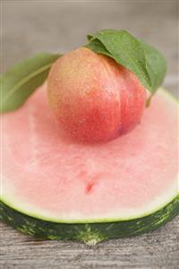 Nectarine with leaves on slice of watermelon