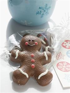 Two chocolate-coated gingerbread men, one in cellophane bag