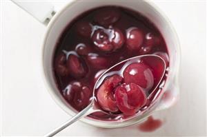 Cherry compote in pan and on spoon