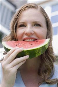 Young woman biting into a slice of watermelon