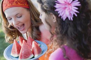 Two young women with wedges of watermelon