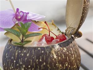 Coconut drink with pineapple, cocktail cherry and orchid