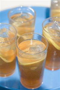 Several glasses of iced tea on a tray