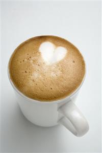 Cup of cappuccino with heart in milk froth