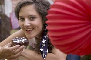 Woman eating a brownie on the 4th July (USA)