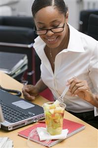 Woman eating fruit salad in the office