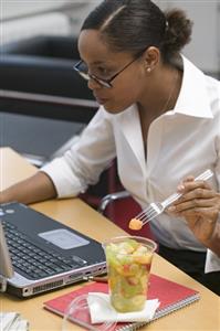 Woman eating fruit salad in the office