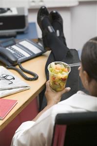 Woman eating fruit salad in the office