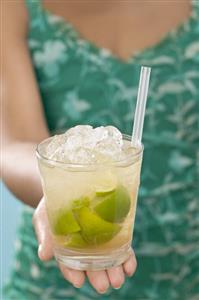 Woman holding glass of Caipirinha