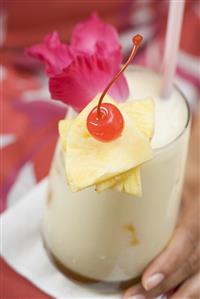 Woman holding Piña Colada (close-up)