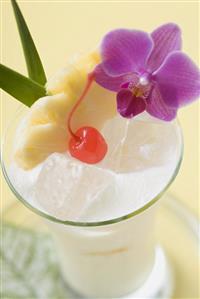 Piña Colada with pineapple, cocktail cherry and orchid