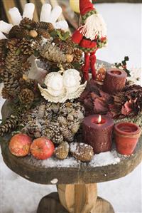 Christmas decorations on wooden table in snowy garden