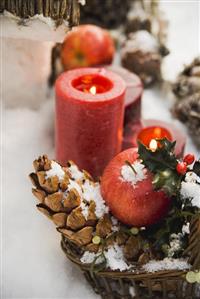 Christmas decorations: apples, cones and candles in snow