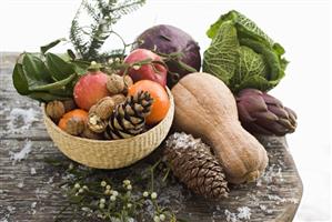 Still life: apples, vegetables, nuts & cones on wooden table