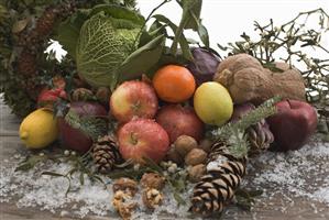 Fruit, vegetables, nuts, fir cones on wooden table out of doors