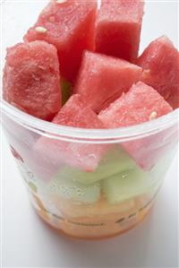 Diced melon and watermelon in plastic tub (close-up)