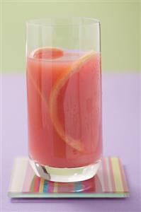 Glass of pink grapefruit juice with slices of grapefruit