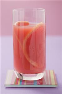 Glass of pink grapefruit juice with slices of grapefruit