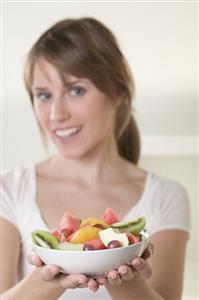 Woman holding dish of fruit salad