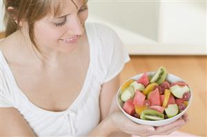 Woman holding dish of fruit salad