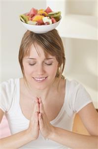 Woman balancing dish of fruit salad on her head