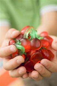 Child's hands holding cherry jelly sweets