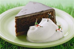 Piece of Sacher torte with cream and football figures