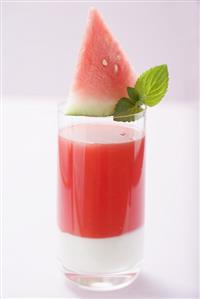 Watermelon drink with wedge of watermelon and mint leaves