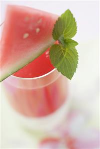 Watermelon drink with wedge of watermelon and mint leaves