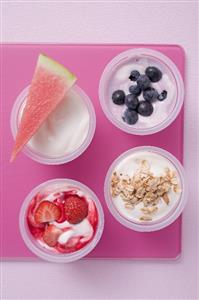 Assorted yoghurts with berries, melon and cereal