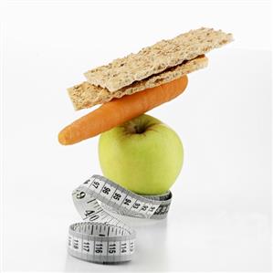 Apple, carrot and crispbread with tape measure