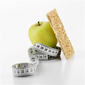 Green apple and crispbread with tape measure