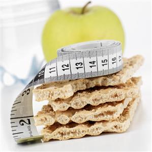 Crispbread with tape measure, apple in background