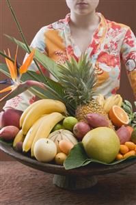 Woman holding bowl of exotic fruit