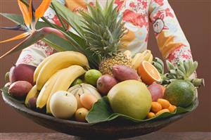 Woman holding bowl of exotic fruit