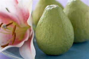 Three guavas, orchid beside them