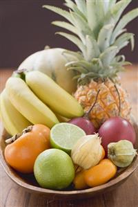 Exotic fruit and citrus fruit in wooden bowl