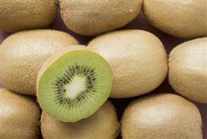 Half a kiwi fruit on several whole kiwi fruits