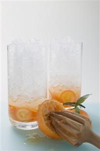 Citrus fruit and crushed ice in two tall glasses