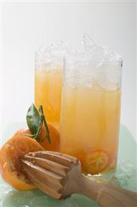 Citrus fruit and crushed ice in two tall glasses